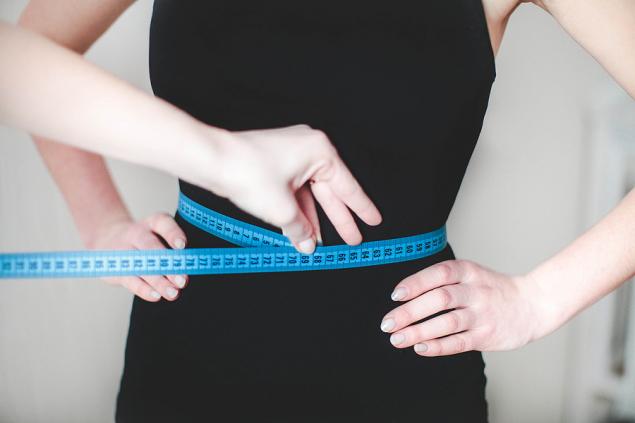 девушка снимает мерки сантиметровой лентой